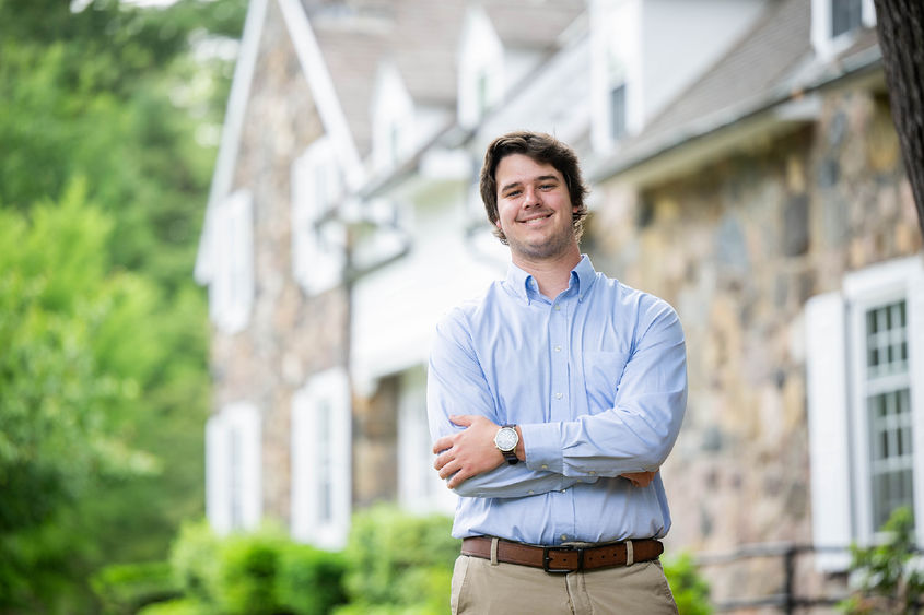Josiah Burkett stands in front of Glenhill Farmhouse at Penn State Behrend.