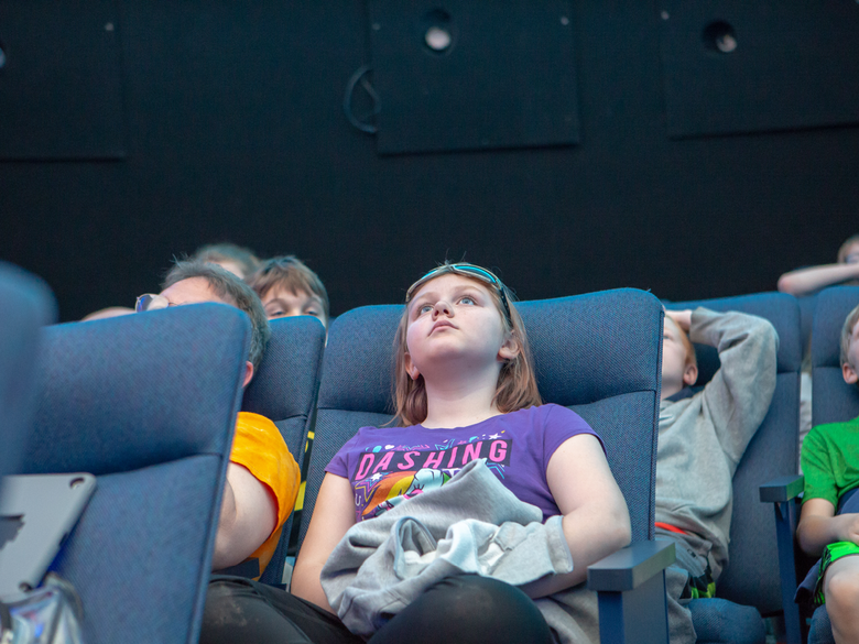 Middle school students attend a planetarium show.