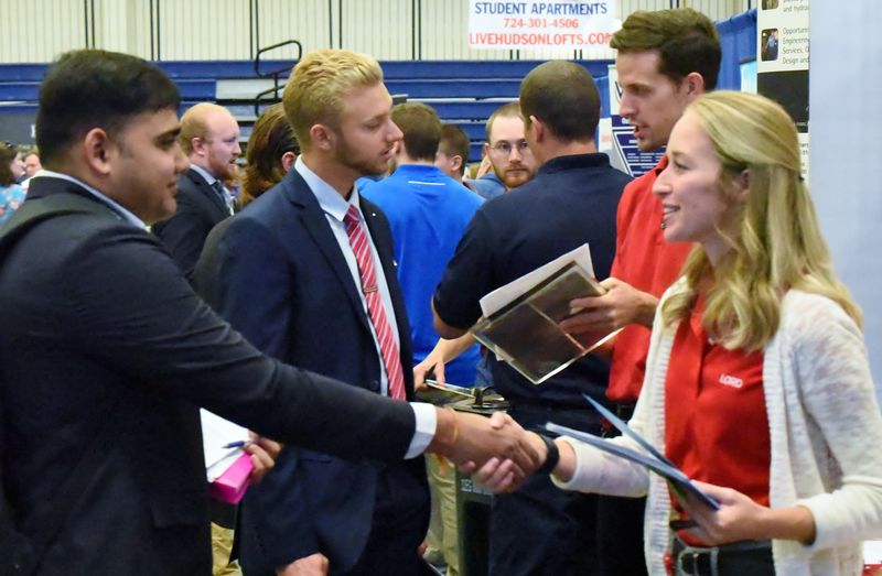 A student shakes a recruiter's hand at the Penn State Behrend fall Career and Internship Fair.
