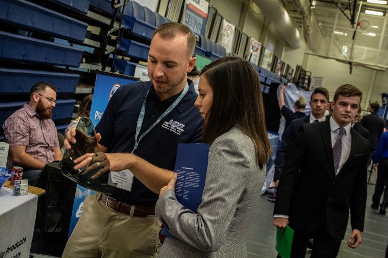 A corporate recruiter shows a product to a student at Penn State Behrend's fall Career and Internship Fair.