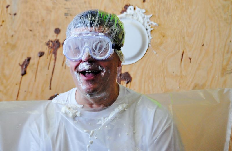 Penn State Behrend professor Bill Lasher is hit with a cream pie during a fundraiser.