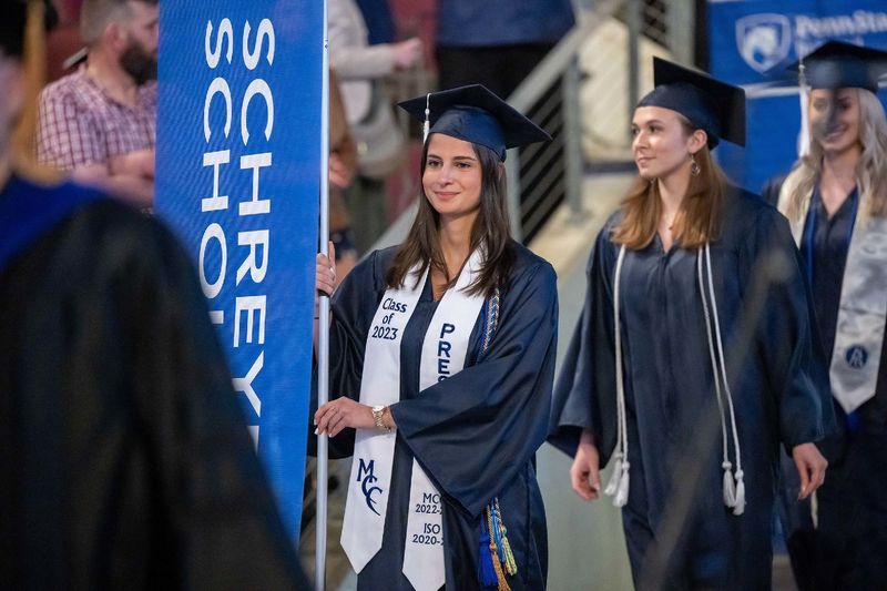 A student marshal enters Erie Insurance Arena during Penn State Behrend's spring 2023 commencement ceremony.