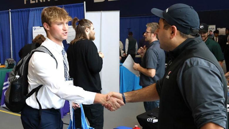 A Penn State Behrend student shakes a recruiter's hand during a career fair.