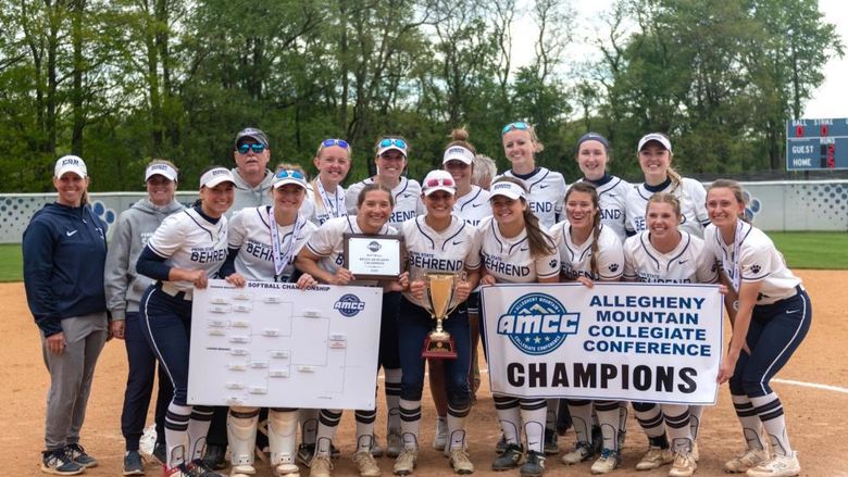 The Penn State Behrend softball team poses with the AMCC championship banner.