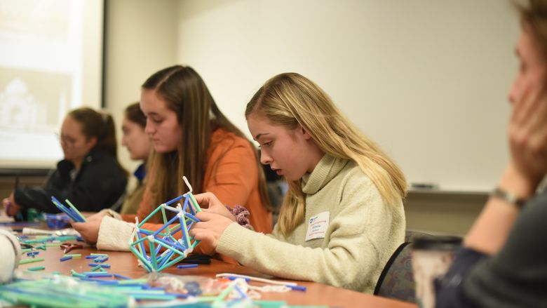 Victoria Purchase works to create a dome during Women in Engineering Day at Penn State Behrend.