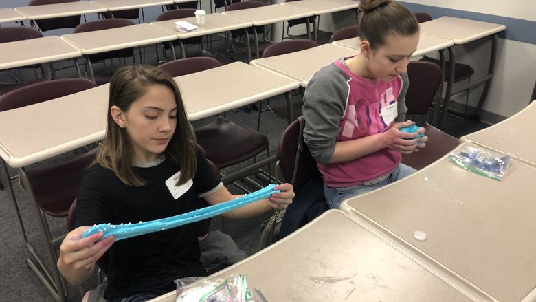 Danica Park, left, and Kristine Wurst play with the slime they created during "The Science of Slime" workshop at Penn State Behrend's Math Options Career Day.