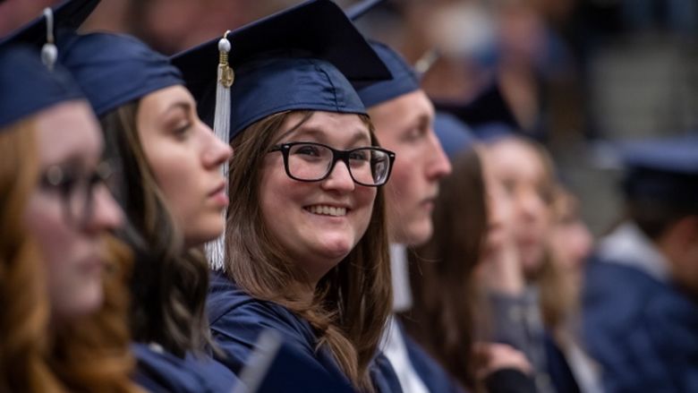 A Penn State Behrend graduate smiles during the college's commencement ceremony.