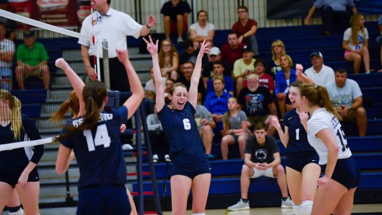 Members of the Penn State Behrend volleyball team celebrate a win.