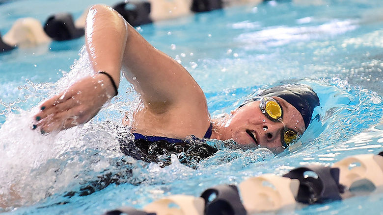 A Penn State Behrend swimmer competes in a freestyle race.