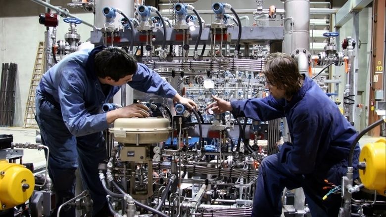 Two employees work in a manufacturing setting.