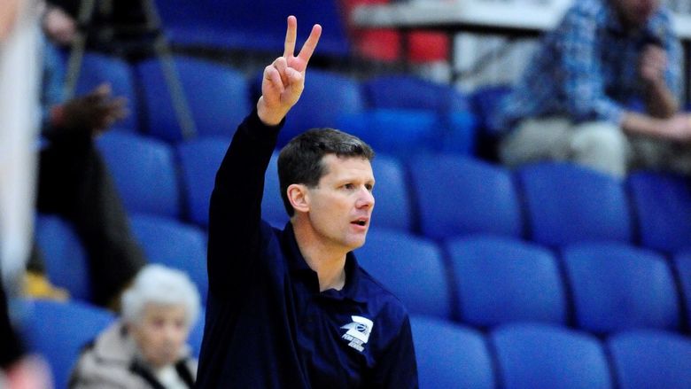 Penn State Behrend men's basketball coach Dave Niland signals to his team from the sideline.