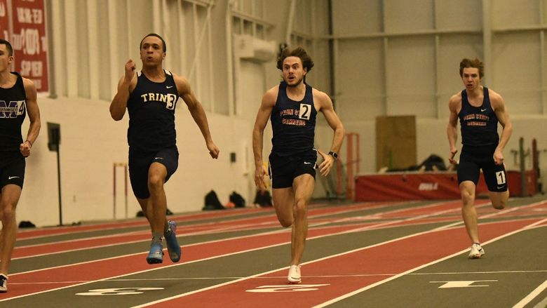 Penn State Behrend runners race around an indoor track.