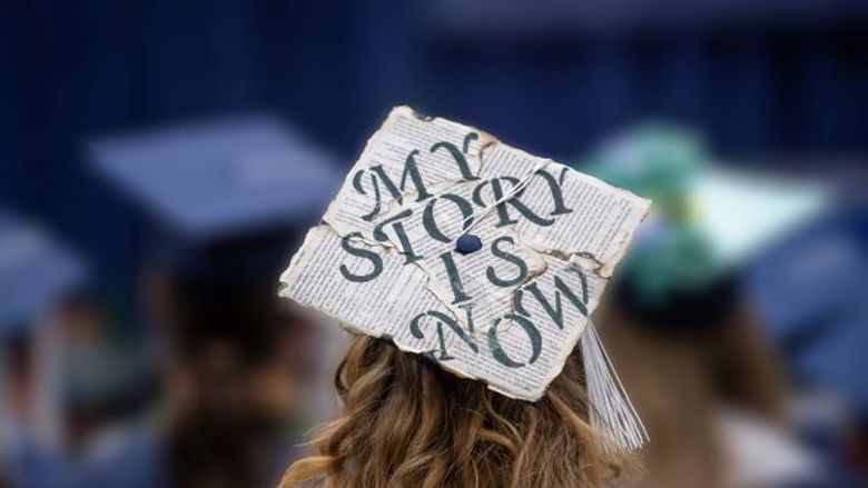 A close-up of a decorated mortarboard cap at a Penn State Behrend commencement program.