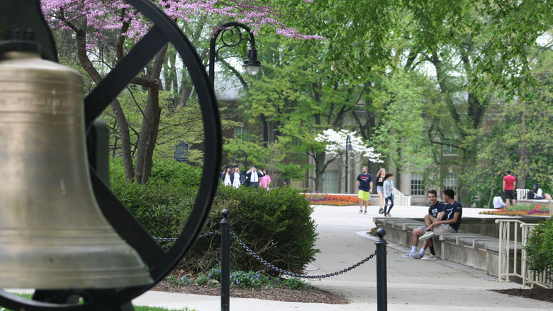 Students mingle around Old Main on the University Park campus