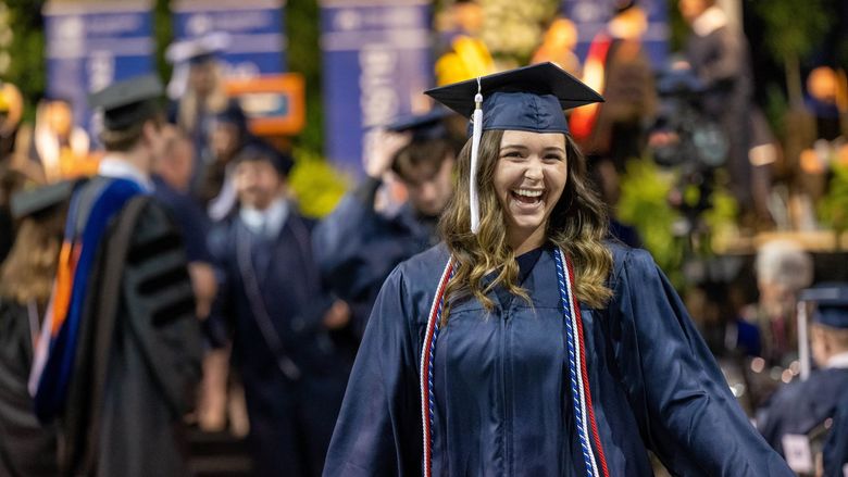 A Penn State Behrend graduate leaves the commencement stage after receiving her diploma.