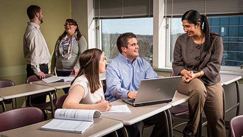 Four students talk with an instructor in Penn State Behrend's Master of Professional Accounting program.
