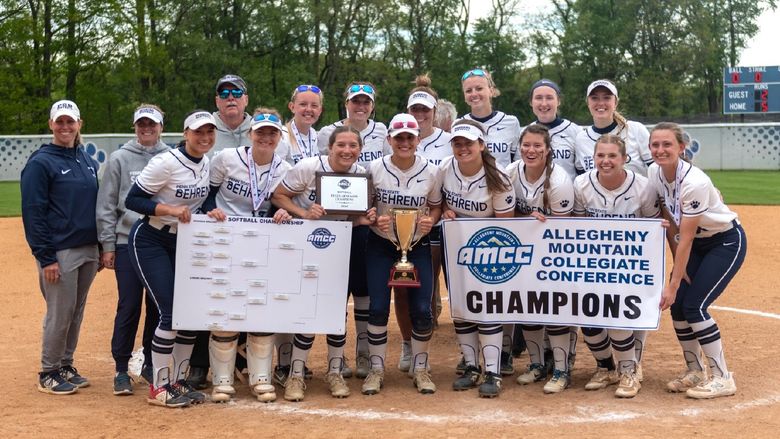 The Penn State Behrend softball team poses with the AMCC championship banner.