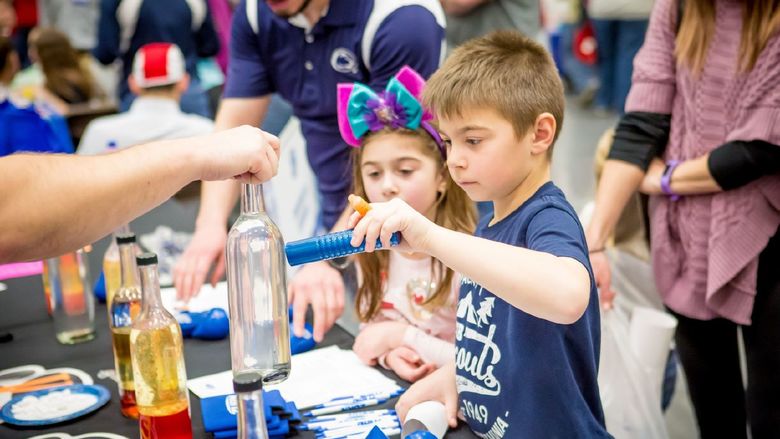 Two children play at a science table during the Penn State Behrend STEAM Fair in 2020.