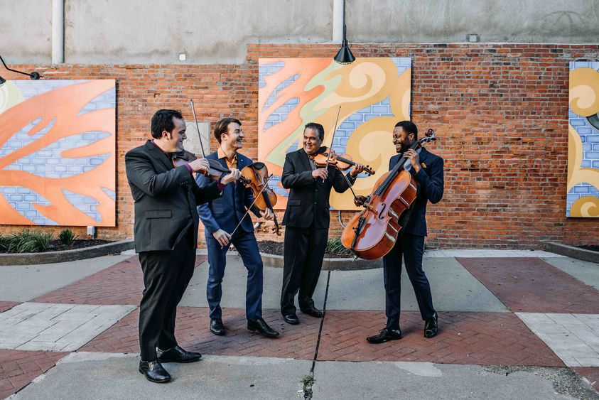 The Turtle Island Quartet performs in a street.