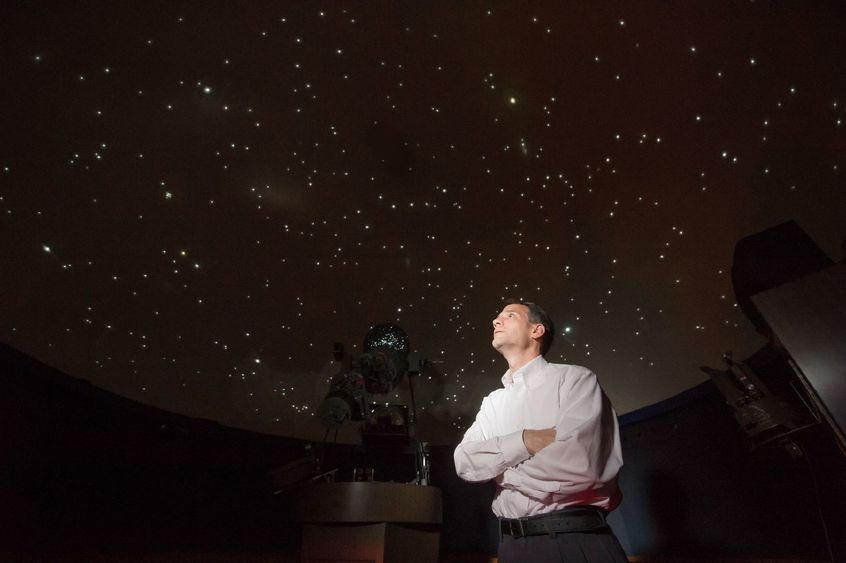 Jim Gavio, director of Yahn Planetarium, looks up at the starfield on the planetarium's ceiling.