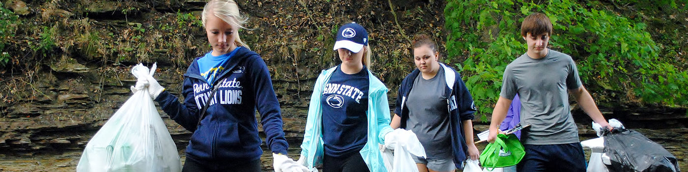 Four Behrend students cleaning up a creek in Wintergreen Gorge.