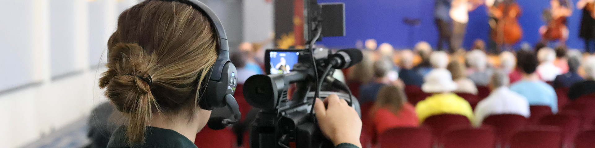 A female student uses a video camera to record an event