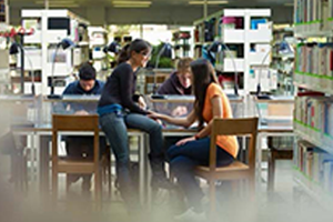 Men and women sitting at a table in a library