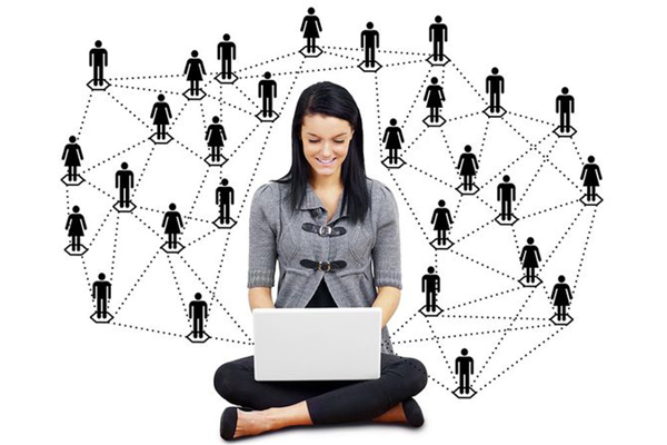 Female with computer on lap and surrounded by web of male and female silhouette icons