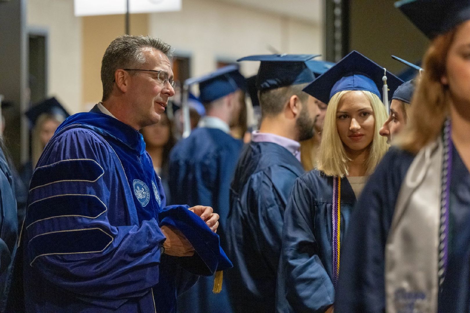 Penn State Behrend Chancellor Ralph Ford talks with students prior to the college's spring 2022 commencement program.