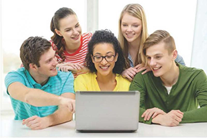 Five students looking at a computer