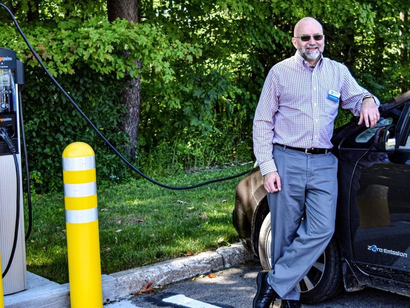 Penn State Behrend faculty member Michael Rutter charges an electric vehicle at a charging station on campus.