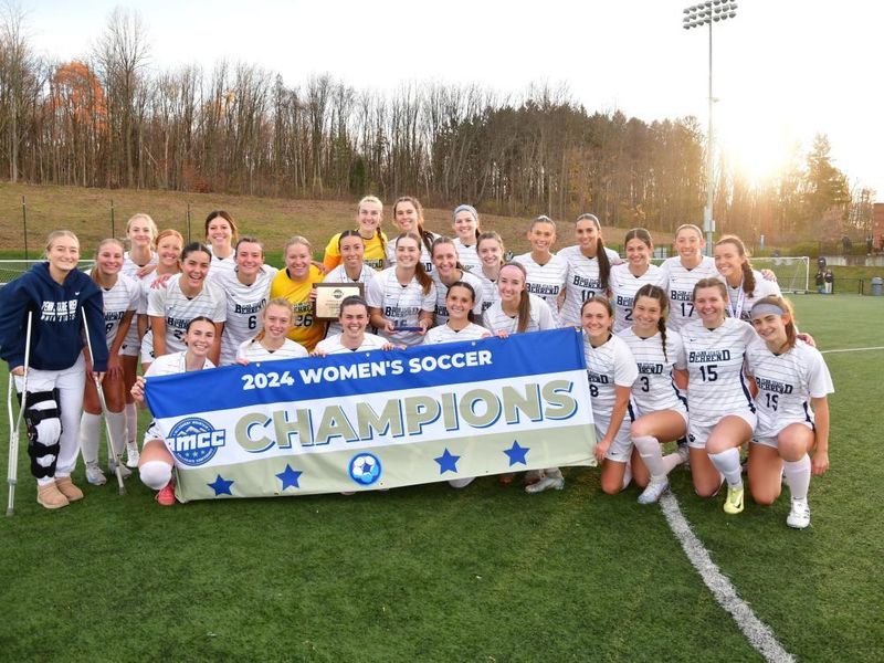 The Penn State Behrend women's soccer team poses with the AMCC championship banner.