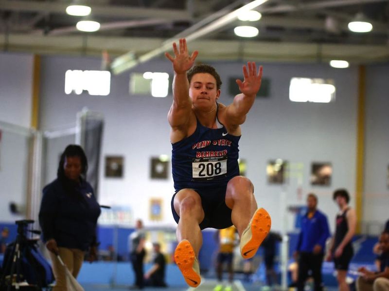 A Penn State Behrend track-and-field athlete competes in the long jump.