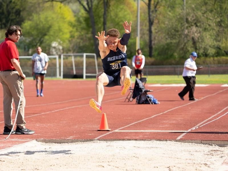 A Penn State Behrend student-athlete competes in the long jump at an outdoor track.