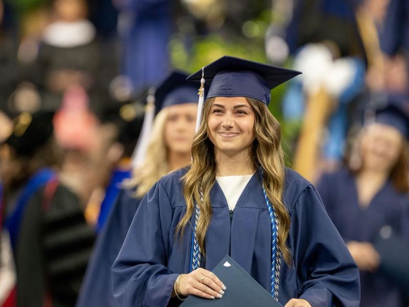 A Penn State Behrend graduate smiles after receiving her degree.