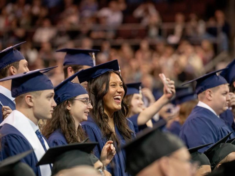 Students smile and point during Penn State Behrend's spring commencement program.