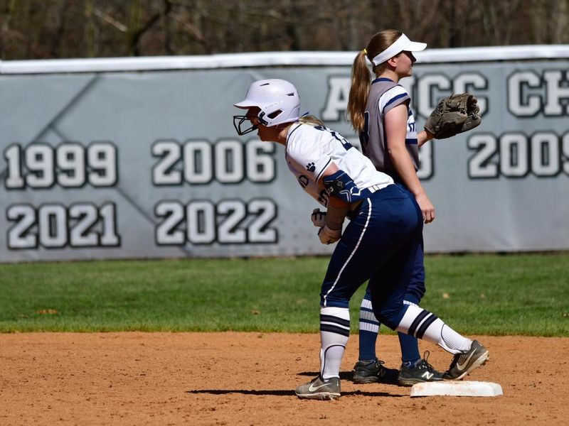 A Penn State Behrend softball player cheers while standing on base.