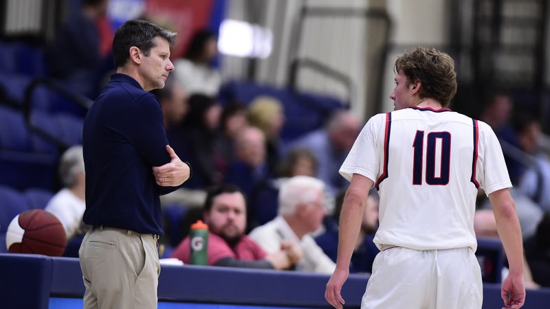Penn State Behrend men's basketball coach Dave Niland talks with his son, Andy Niland, during a game.