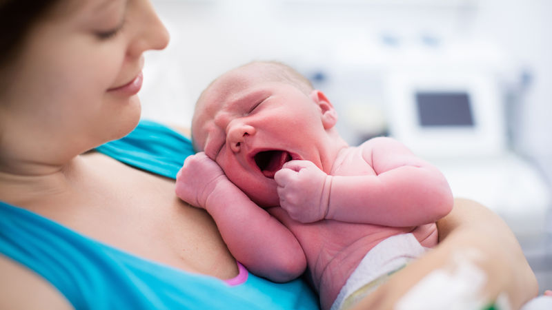 A mother holds a newborn child.
