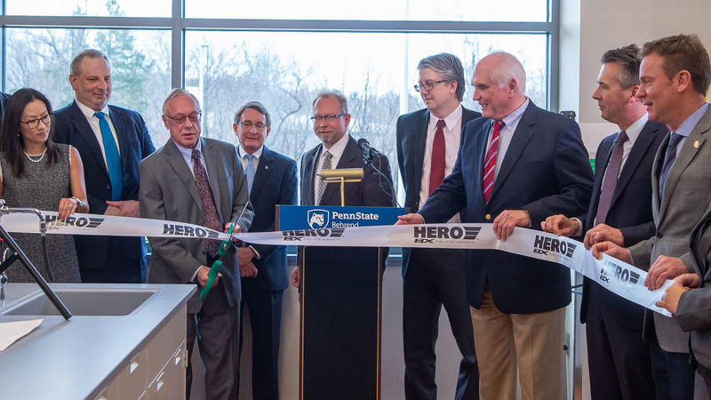 A group gathers to cut the grand-opening ribbon at a HERO BX lab at Penn State Behrend.