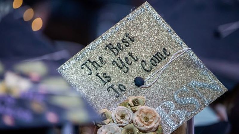 A close-up of a decorated mortarboard cap at a Penn State Behrend commencement program.