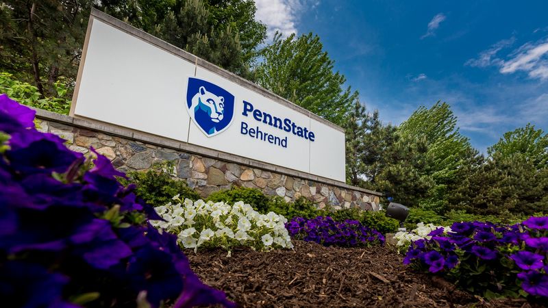Flowers surround the sign at the entrance to Penn State Behrend
