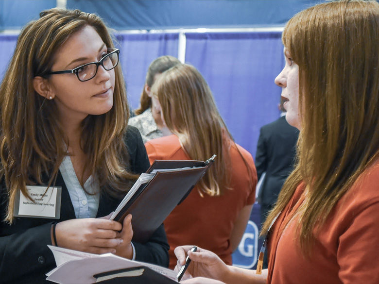 A student meets with an employer at the annual career fair.