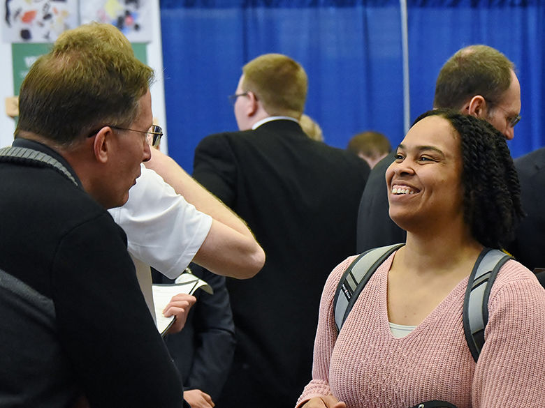 A female student talking with a potential employer at a Behrend Career and Internship Fair