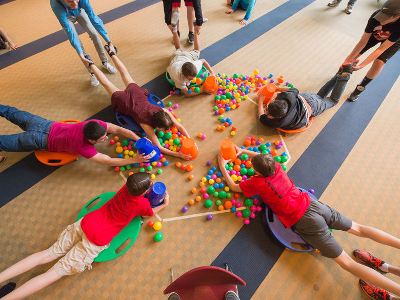 Students play a game with colorful balls at a CORE event.