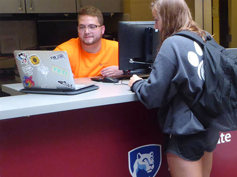 Student consultant at the Hammermill Service Desk assisting a student with her laptop.