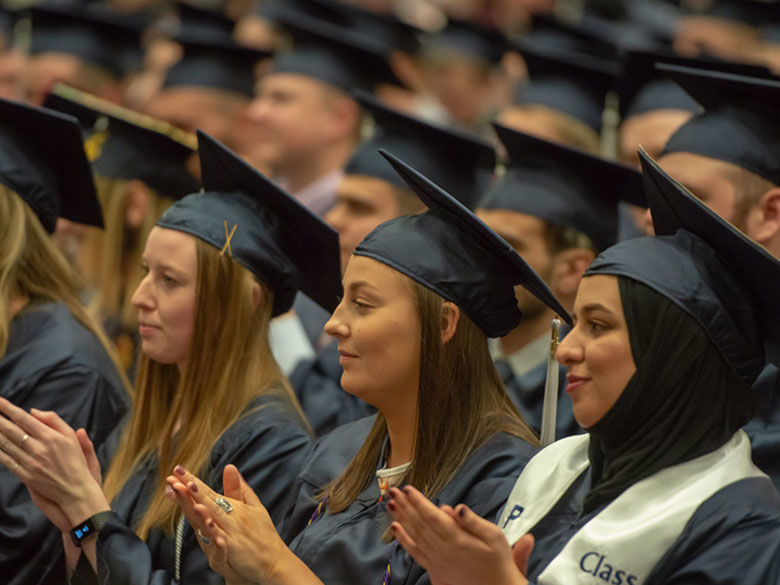 Three female Penn State Behrend graduates participate in commencement.