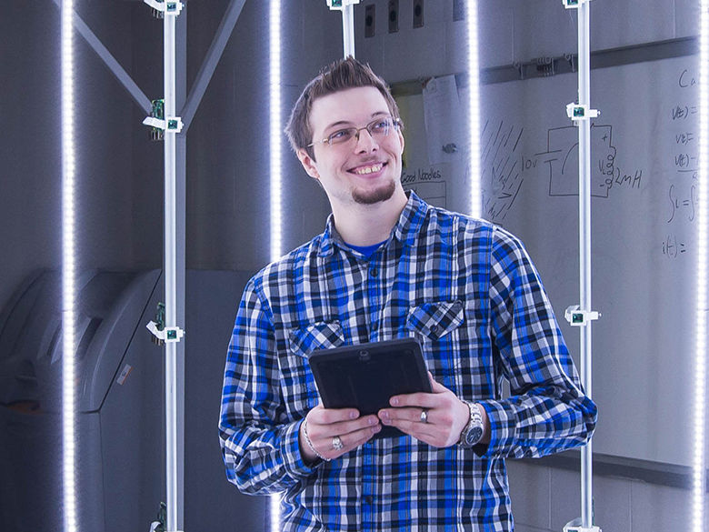 A male engineering student standing in a camera cage