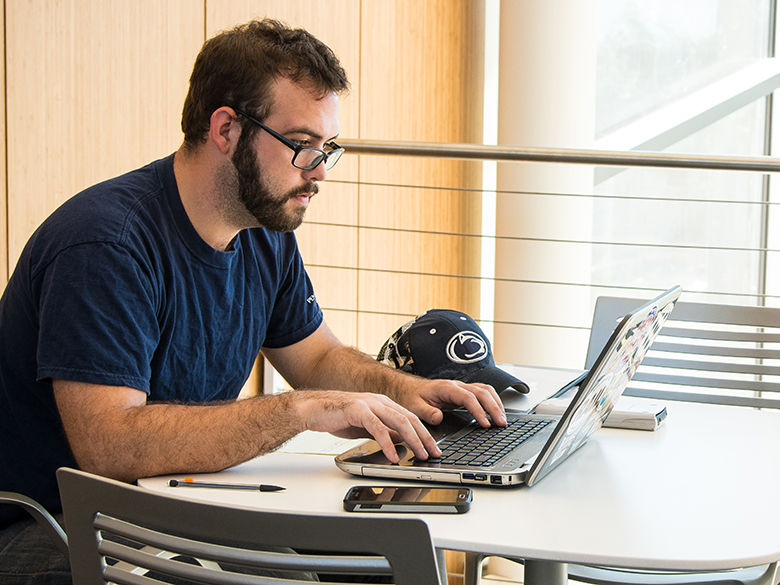 A Penn State Behrend student using a laptop computer to do coursework