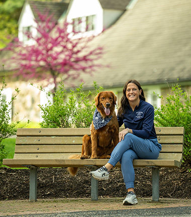 Millie the golden retriever, with her "mom", Kelly Wilson, sit in front of the Glenhill Farmhouse. Millie is training to be an emotional support dog.